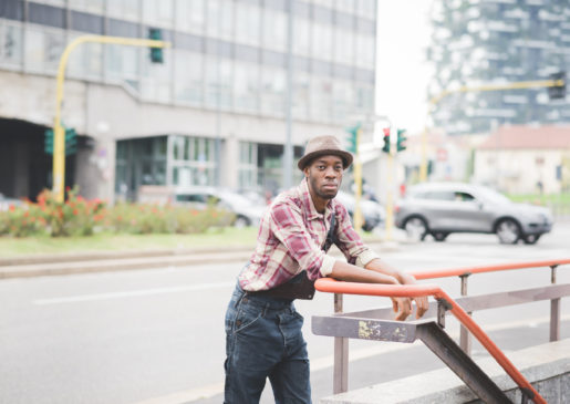 Thinking man man leaning against a hand rail near a street, thinking deeply about something