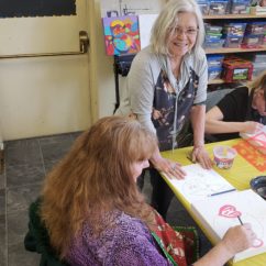 artists at work two artists paint or draw in the CMHA's wellness developments center with supervision from another artist
