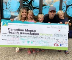 CMHA donation family of 5 is holding a large check payable to CMHA Kelowna for $72000 the family looks very happy and the 3 kids can barely hold up the massive check