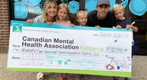 CMHA donation family of 5 is holding a large check payable to CMHA Kelowna for $72000 the family looks very happy and the 3 kids can barely hold up the massive check