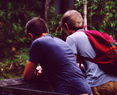 Friend-Suicide-How-to-Help Two boys learning over a fence talking to eachother about their mental health