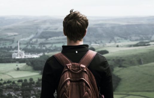 Teen with backpack Teenager staring out over a foggy valley wearing a backpack